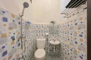 a bathroom with a toilet and a sink at Namirah Guesthouse Redpartner in Balikpapan