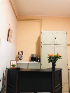 a room with a refrigerator and a table with flowers at Two single beds' room in sremski karlovic center in Sremski Karlovci