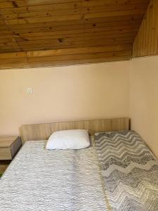 a bed in a room with a wooden ceiling at Two single beds' room in sremski karlovic center in Sremski Karlovci