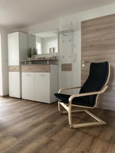 a black chair in a room with a kitchen at Brunnerhof Urlaub auf dem Land in Hartenstein