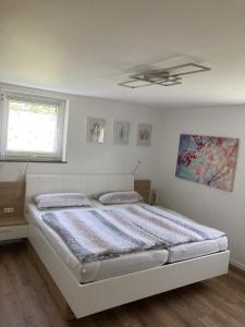 Schlafzimmer mit einem weißen Bett und einer Decke in der Unterkunft Brunnerhof Urlaub auf dem Land in Hartenstein