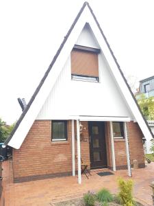uma pequena casa de tijolos com um telhado branco em Kampweg 4 em Cuxhaven