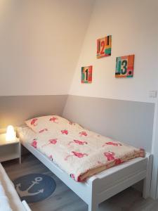 a small bed in a room with a bedspread on it at Kampweg 4 in Cuxhaven