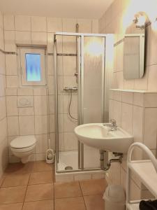 W łazience znajduje się prysznic, umywalka i toaleta. w obiekcie Satelsrönne 8 w mieście Cuxhaven