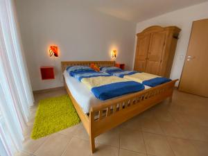 Un dormitorio con una cama con almohadas azules. en Duhner Brise, Ferienwohnung 2, en Duhnen