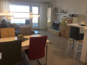 cocina y sala de estar con mesa y sillas en Nautilus, Ferienwohnung 12 inkl Strandkorb, en Cuxhaven