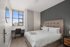 a bedroom with a large white bed and a window at The Median Serviced Apartment Collection in Johannesburg