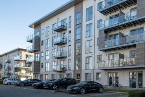 een appartementencomplex met auto's geparkeerd op een parkeerplaats bij Alder House Serviced Apartment Maidenhead by 360stays in Maidenhead
