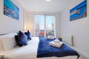 een slaapkamer met een bed met twee handdoeken erop bij Alder House Serviced Apartment Maidenhead by 360stays in Maidenhead
