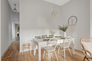 a white dining room with a white table and chairs at Boho Chic - your bohemian home in Antwerp in Antwerp