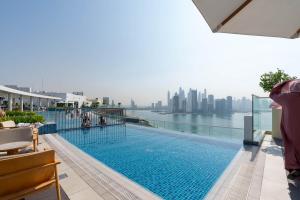 uma piscina no telhado de um edifício com vista para a cidade em Tamm - Prime Residence with Unrivaled Palm Jumeirah Views em Dubai