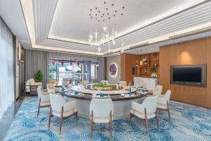 Holiday Inn Express Pingchang, an IHG Hotel في Bazhong: غرفة طعام كبيرة مع طاولة وكراسي كبيرة