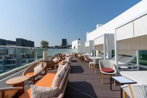 uma fila de cadeiras e mesas no telhado de um edifício em Tamm - Prime Residence with Unrivaled Palm Jumeirah Views em Dubai