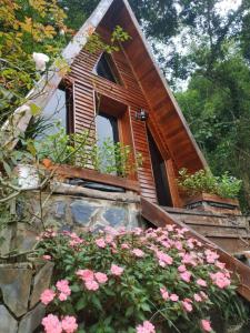 ein kleines Haus mit einem Fenster und rosa Blumen in der Unterkunft Eco Rose Homestay in Diện Biên Phủ