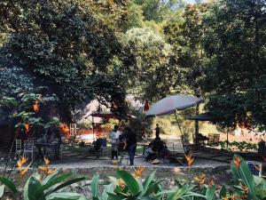 a group of people sitting under an umbrella in a park at Eco Rose Homestay in Diện Biên Phủ