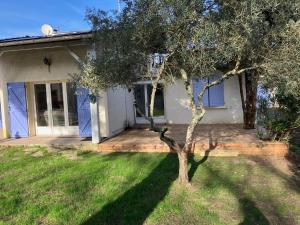 a house with a tree in the front yard at Maison familiale au cœur du bassin d'Arcachon in Biganos
