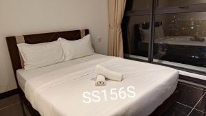 ein weißes Bett mit einem Handtuch darüber in der Unterkunft Urban Suite_無敵檳城大橋景Premium套房「家庭式套房」 Max8 Pax in Jelutong