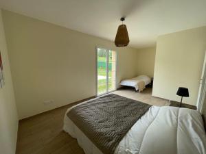 1 Schlafzimmer mit 2 Betten und einem großen Fenster in der Unterkunft Les Amandiers*Piscine chauffée*3 kms centre historique SARLAT in Sarlat-la-Canéda