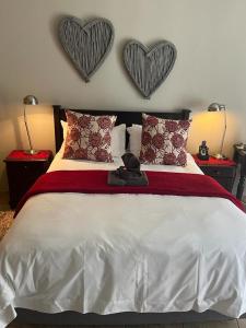 a bedroom with a bed with two hearts on the wall at Sanyati Guesthouse in Kathu