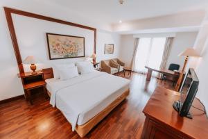 Habitación de hotel con cama y TV en Arion Suites Hotel en Bandung