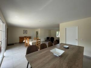 ein Esszimmer und ein Wohnzimmer mit einem Tisch und Stühlen in der Unterkunft Les Amandiers*Piscine chauffée*3 kms centre historique SARLAT in Sarlat-la-Canéda