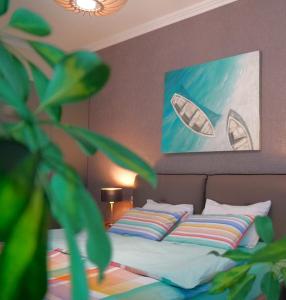 a bedroom with a bed with a painting on the wall at Season Suite Apart-Hotel in Batumi