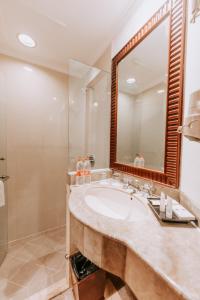 a bathroom with a sink and a mirror at Arion Suites Hotel in Bandung