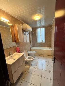 a bathroom with a toilet and a sink and a tub at APARTMENTO LUMINOSO in Ciudad de Malabo