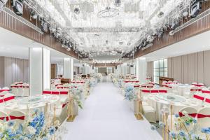 einen Bankettsaal mit weißen Tischen und blauen Blumen in der Unterkunft Holiday Inn Express Pingchang, an IHG Hotel in Bazhong