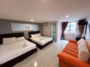 a hotel room with two beds and a couch at Your Hotel Klang in Klang