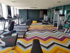 a fitness room with a gym with tread machines at Cool 1BR Acqua Livingstone w/ Netflix, Pool & Gym in Manila