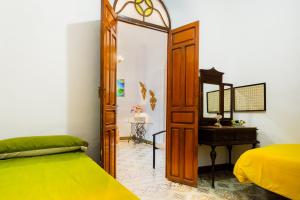 1 dormitorio con cama, espejo y escritorio en Una casa azul, en Manzanilla