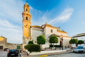 a church with a clock tower on a street at Una casa azul in Manzanilla