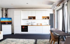 a kitchen with white cabinets and a table at ZAGREB HOUSE MEDVEŠČINA/WITH POOL in Zagreb