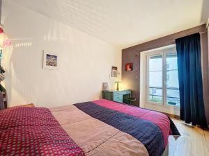 een slaapkamer met een groot bed en een raam bij Bijou de la Corderie - Hyper Central & Spacieux - Les Frères de la Loc' in Parijs