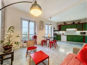 een keuken met groene kasten en een tafel met rode stoelen bij Bijou de la Corderie - Hyper Central & Spacieux - Les Frères de la Loc' in Parijs