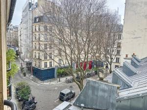 een boom in het midden van een straat met gebouwen bij Bijou de la Corderie - Hyper Central & Spacieux - Les Frères de la Loc' in Parijs