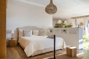ein weißes Schlafzimmer mit einem Bett und einem hängenden Licht in der Unterkunft Suite in Villa Torto with pool in Monopoli + 15 Fotos