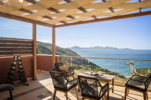フィスカルドにあるEntheos Private Villa Fiskardo Kefalonia Greeceの海の景色を望むバルコニー(テーブル、椅子付)