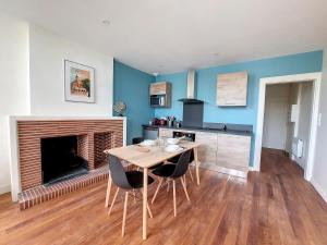 a dining room with a table and a fireplace at LE CARILLOUN in Mirande