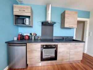 a kitchen with a stove and a sink at LE CARILLOUN in Mirande +9 photos
