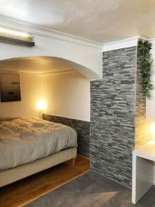 マルベーリャにあるLoft 20のレンガの壁、ベッド付きのベッドルーム1室