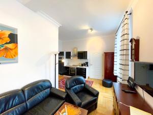 sala de estar con sofá de cuero negro y silla en hochwertig ausgest. App. mit WLAN und kostenl. Stellplatz, en Heringsdorf