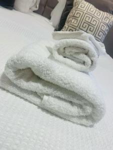 a pile of white towels on a bed at Stunning Cottage in 15 acres in Brampton