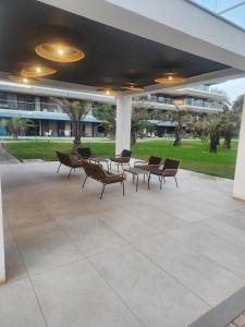 um grupo de cadeiras e mesas sob um edifício em Costa Vista- Standard bedroom flat#501 with private pool- kololi sands em Sere Kunda
