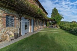 a brick house with a grass yard next to a building at Villa Marlia in Lucca