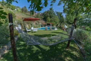 a hammock in a yard with a swimming pool at Villa Marlia in Lucca