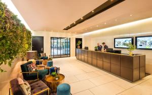 a lobby with people sitting at a reception desk at Lindner Hotel Berlin Ku'damm, part of JdV by Hyatt in Berlin