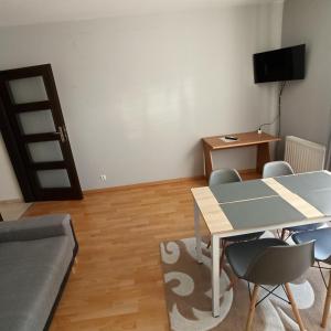 a living room with a table and chairs and a bed at Apartament Dunikowskiego 57m2 in Lublin