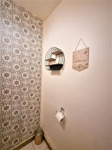 a bathroom with a toilet paper roll on a wall at Appart' convivial 3 Ch 73m² à proximité de Paris in Châtillon